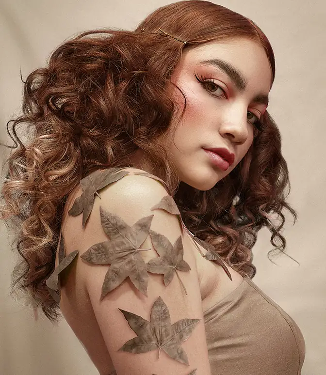 Fotografía beauty de mujer con hojas de árbol en el brazo