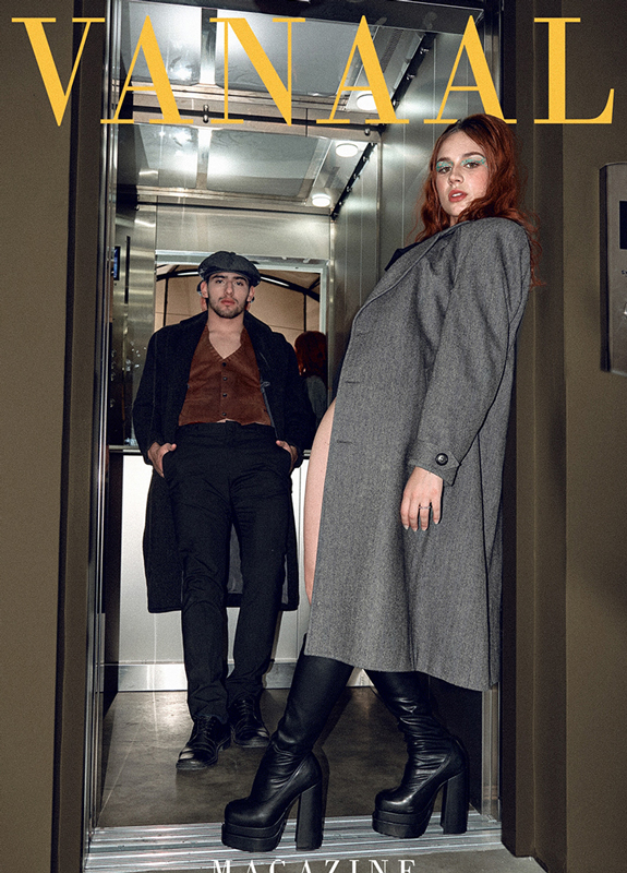 Portada editorial mujer con gabán gris y botas largas hasta las rodillas, en la puerta de un ascensor de color dorado