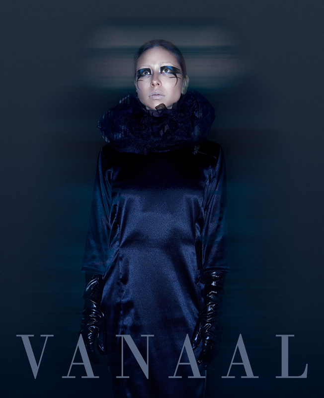 Portada editorial mujer con traje largo de color azul, guantes negros y maquillaje artístico azul oscuro, mirando al infinito