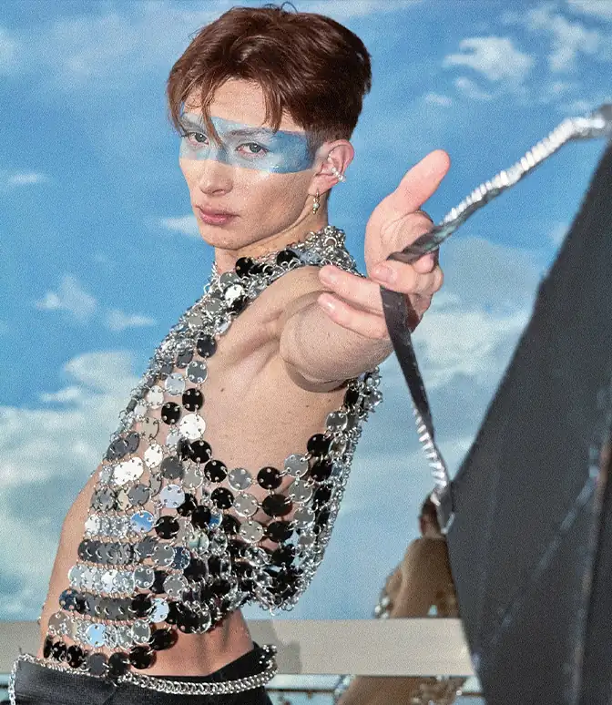 Fotografía editorial de hombre con maquillaje azul y chaleco de escamas plateadas