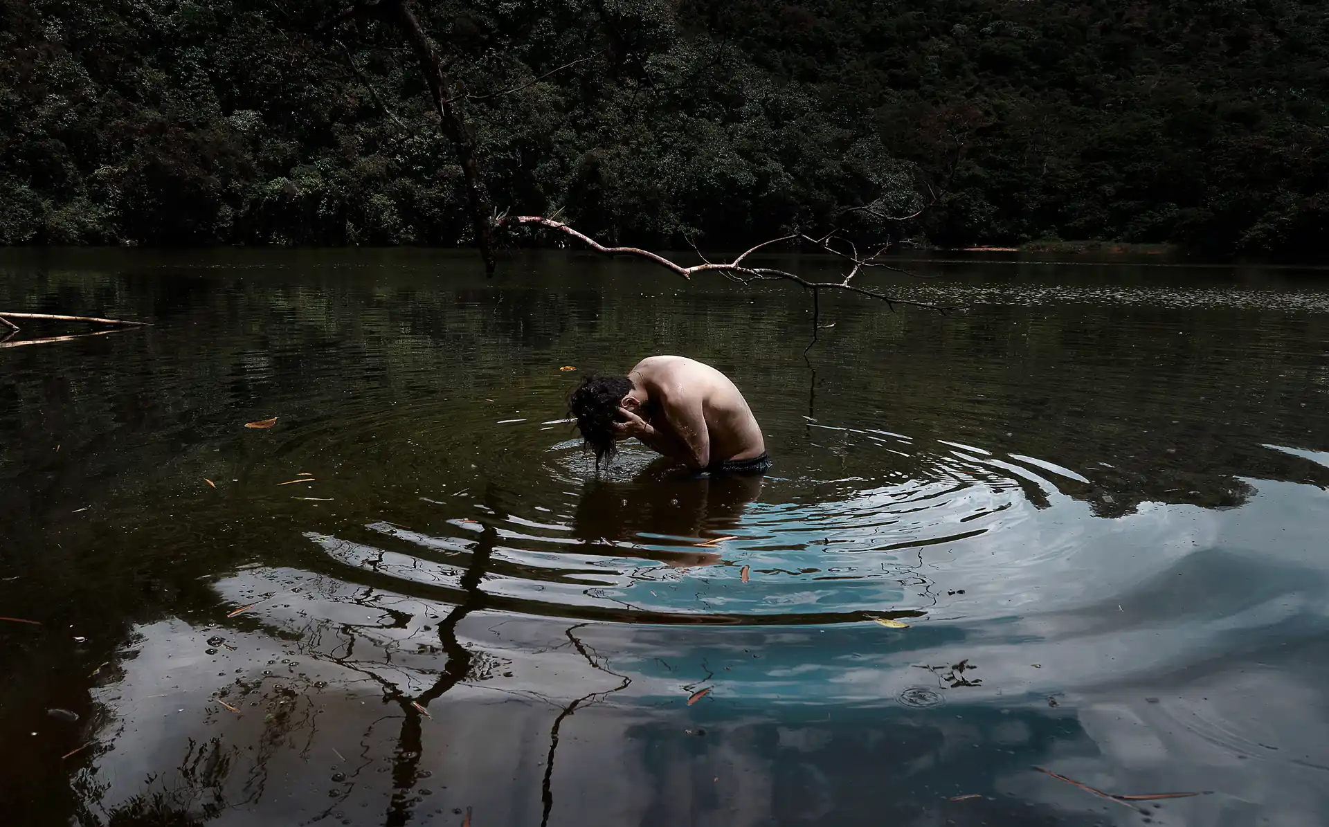 Hombre observando su reflejo en medio de un lago