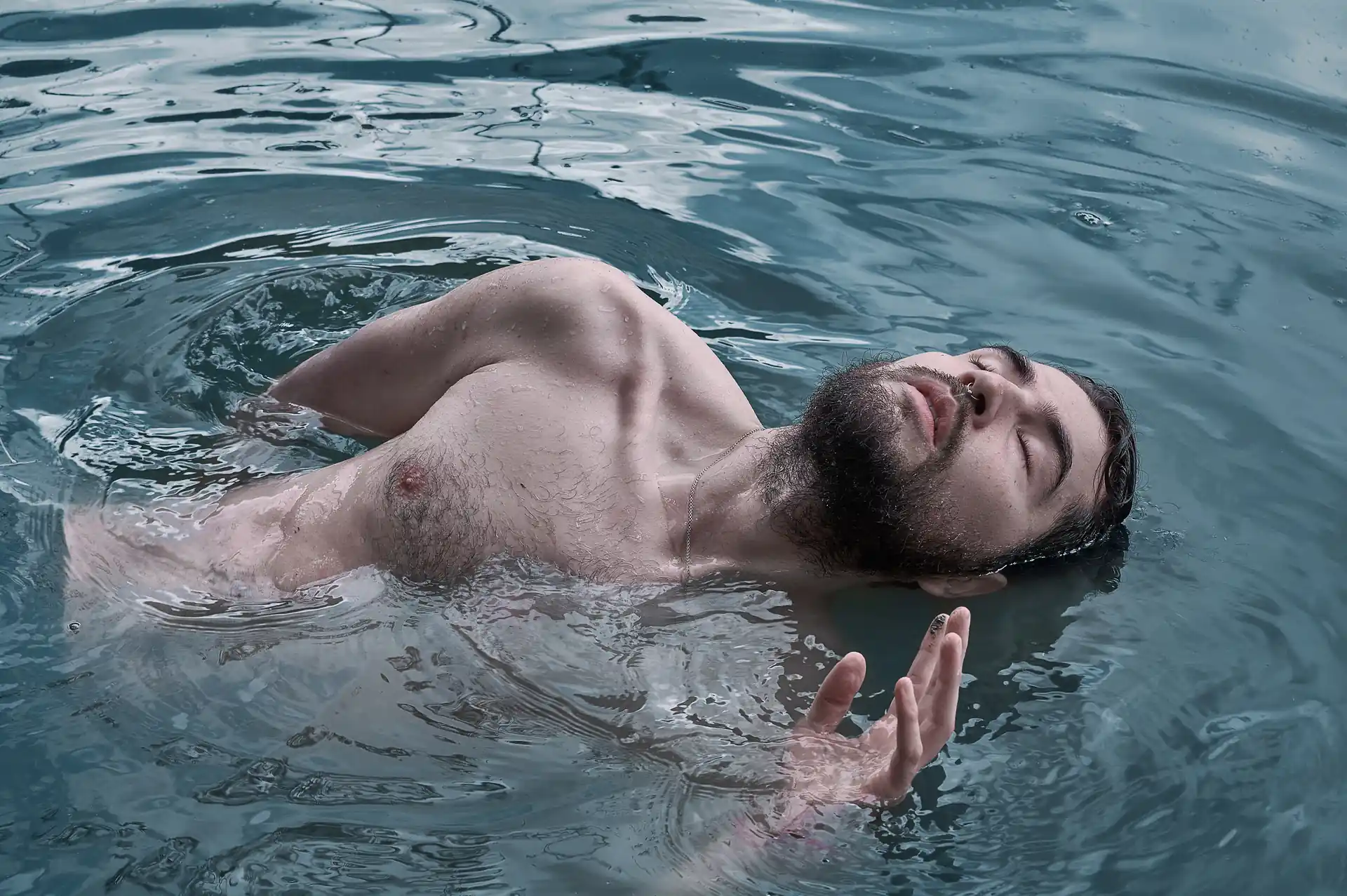 Hombre saliendo del un lago con el torso descubierto