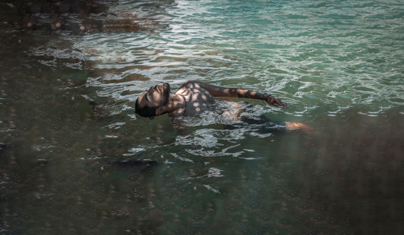Artistic photography man floating in the water of a lake.