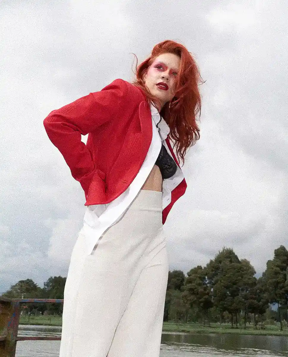 Fotografía editorial de na amujer con las manos en la cintura, con saco de color rojo