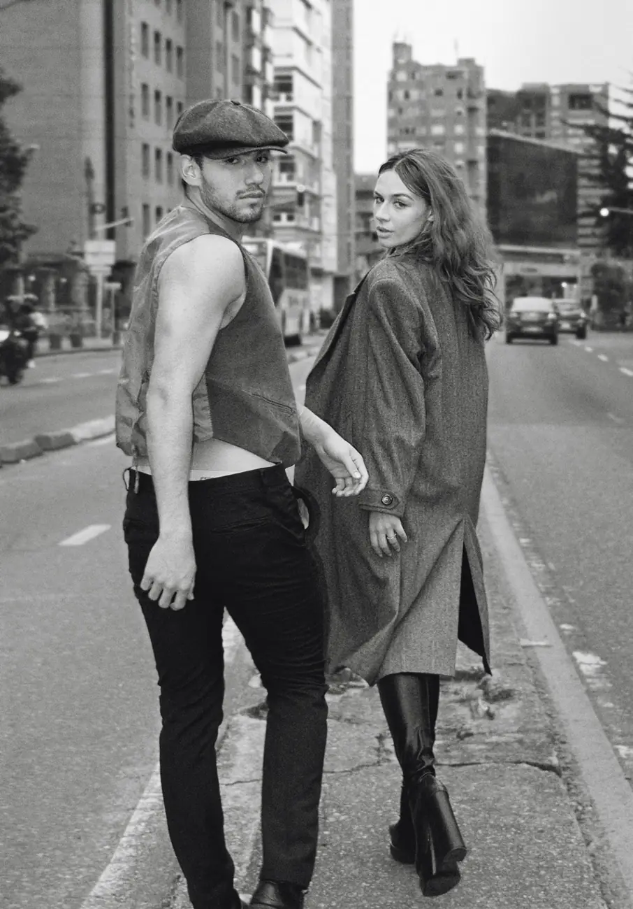 Fotografía de un hombre y una mujer camicando de espaldas a la cámara por mitad de la avenida
