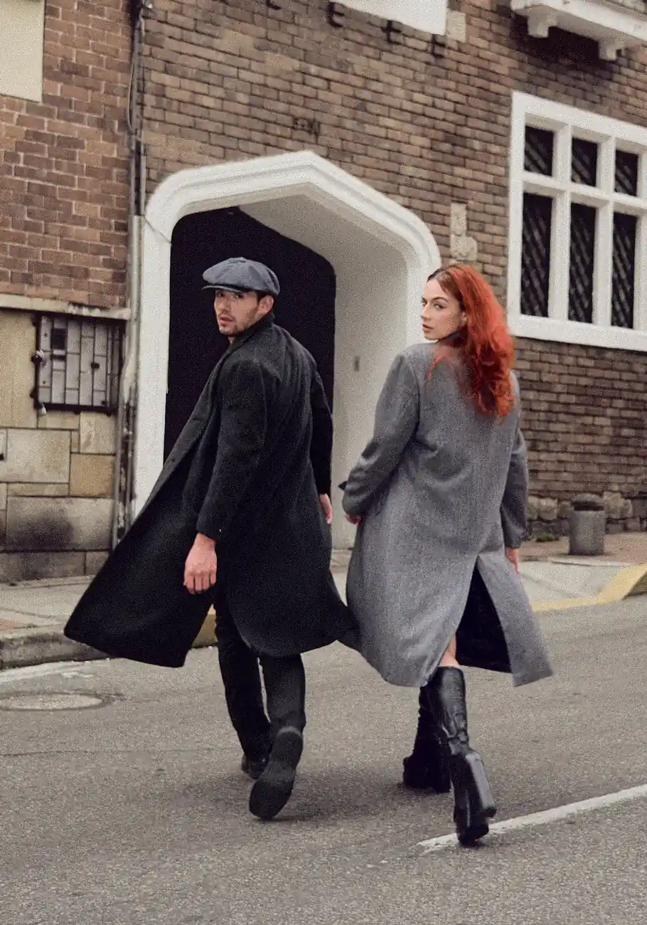 Fotografía de un hombre y una mujer vestidos de gabán caminando de espaldas a la cámara