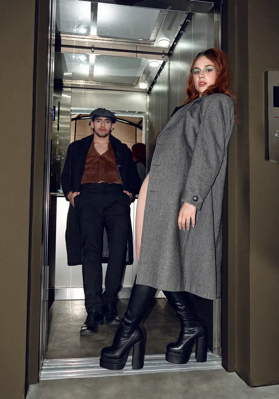 Fotografía de una pareja en un ascensor rescostados en la puerta