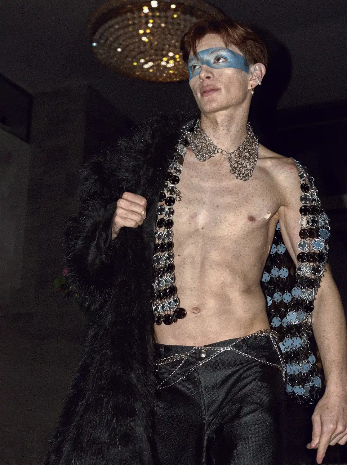 Fotografía editorial de hombre con gabán peludo, y con el torso desnudo